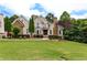 Beautiful two-story home with stone and brick facade, manicured lawn, and mature trees creating an inviting curb appeal at 1360 Mount Mickinley Dr, Grayson, GA 30017