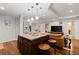 Kitchen island with granite countertops, wooden cabinets, and stools for seating open to the living area at 1360 Mount Mickinley Dr, Grayson, GA 30017