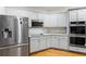 Modern kitchen showcasing white cabinets, stainless steel appliances, granite countertops, and hardwood floors at 1360 Mount Mickinley Dr, Grayson, GA 30017