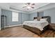 Spacious primary bedroom features a tray ceiling, hardwood floors, and a full furniture set with built-in headboard at 1360 Mount Mickinley Dr, Grayson, GA 30017