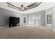 Spacious main bedroom with neutral carpet, large windows, and ceiling fan with doors leading outside at 1360 Mount Mickinley Dr, Grayson, GA 30017