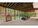 A covered patio with outdoor seating and a view of a lush, wooded backyard at 1360 Mount Mickinley Dr, Grayson, GA 30017