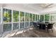 Bright screened porch overlooking a wooded yard features a ceiling fan and outdoor dining set at 1360 Mount Mickinley Dr, Grayson, GA 30017