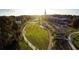 Beautiful aerial view overlooking a city park with green lawn, a walkway, trees, parking lot, and buildings at 1383 Van Allen Ct, Dacula, GA 30019