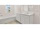 Bright bathroom featuring a separate tub, double sink vanity, and large mirror at 1383 Van Allen Ct, Dacula, GA 30019