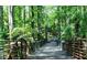 A wooden walking bridge with metal railings over a peaceful wooded path at 1383 Van Allen Ct, Dacula, GA 30019