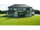 Backyard view of a two-story home with a well-manicured lawn and a covered patio at 3207 Bold Springs Rd, Dacula, GA 30019
