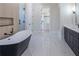 Stylish bathroom featuring a modern tub, walk-in shower, vanity with double sinks and access to the walk-in closet at 3207 Bold Springs Rd, Dacula, GA 30019