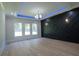Staged bedroom boasts large windows, decorative wall, and light wood floors creating a stylish and inviting space at 3207 Bold Springs Rd, Dacula, GA 30019
