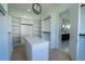 Well-organized walk-in closet with island and custom shelving for clothing and accessories at 3207 Bold Springs Rd, Dacula, GA 30019