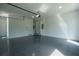 A spacious garage with a sleek epoxy floor, bright lighting, and ample storage shelves at 3207 Bold Springs Rd, Dacula, GA 30019