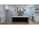 Beautiful kitchen featuring a large island, custom cabinets, modern appliances, and stylish pendant lighting at 3207 Bold Springs Rd, Dacula, GA 30019