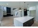 Bright kitchen featuring a center island, white cabinets, modern appliances, and an open layout to the living room at 3207 Bold Springs Rd, Dacula, GA 30019