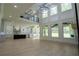 Bright open-concept living room with hardwood floors, large windows, chandelier, and view into the kitchen at 3207 Bold Springs Rd, Dacula, GA 30019