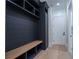 A mudroom with dark built-in cabinets, a light wood bench, and a white door at 3207 Bold Springs Rd, Dacula, GA 30019
