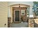 Charming covered front door with stone accents and a welcoming entrance mat, enhancing curb appeal at 429 Mountain View Ln, Woodstock, GA 30188