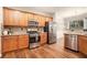 Well-lit kitchen with wood cabinets, stainless steel appliances, and hardwood flooring at 429 Mountain View Ln, Woodstock, GA 30188