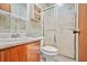 Cozy bathroom features a shower with a glass door, toilet, and vanity with storage at 2454 Fairway Sw Cir, Atlanta, GA 30331