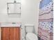 Bright bathroom features a wooden vanity with sink, toilet, and floral shower curtain at 2454 Fairway Sw Cir, Atlanta, GA 30331