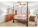 Bright bedroom with a four-poster bed, wooden dresser, and neutral carpeting at 2454 Fairway Sw Cir, Atlanta, GA 30331