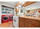 Traditional kitchen featuring light wood cabinets, white appliances, and red washer and dryer appliances at 2454 Fairway Sw Cir, Atlanta, GA 30331
