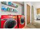 A view of the laundry room with red washer and dryer units, storage shelving, and a utility closet at 2454 Fairway Sw Cir, Atlanta, GA 30331
