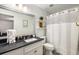 Well-lit bathroom features a vanity with a black countertop and a shower with a white curtain at 2703 Country Park Dr, Smyrna, GA 30080