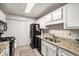 Functional kitchen with granite counters, black appliances, white cabinets, and tiled floors offer durability and style at 2703 Country Park Dr, Smyrna, GA 30080