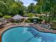 Community pool with plenty of lounge chairs and shady cabana seating surrounded by tall trees at 2703 Country Park Dr, Smyrna, GA 30080