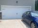 Attached two car garage with a clean white door and a blue car parked on the driveway at 4480 Merrigold Way, Fairburn, GA 30213