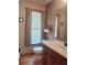 Bathroom with a sink, wood cabinet, and a large window with blinds for privacy at 1131 Steeple Run, Lawrenceville, GA 30043