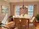 Staged dining area with hardwood floors, lots of light, chandelier, table, and seating for eight at 1131 Steeple Run, Lawrenceville, GA 30043