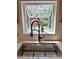 Close-up of a kitchen sink and faucet with a large bright window overlooking a garden at 1131 Steeple Run, Lawrenceville, GA 30043