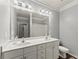 Bathroom has a double vanity with ample lighting, toilet, and neutral color scheme at 1850 Cotillion Dr Unit 3416, Atlanta, GA 30338