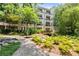 Multi-story building with lush greenery, bridged pond, and garden views at 1850 Cotillion Dr Unit 3416, Atlanta, GA 30338