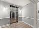 Well-lit hallway featuring a mirror door elevator, gray walls, and attractive wood-look flooring at 1850 Cotillion Dr Unit 3416, Atlanta, GA 30338
