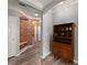 Hallway showcasing a brick accent wall, wood-look floors, and built-in shelving for storage at 1850 Cotillion Dr Unit 3416, Atlanta, GA 30338