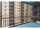Condo balcony with painted floor overlooks neighboring building with caged outdoor spaces at 300 Peachtree Ne St # 20 O, Atlanta, GA 30308