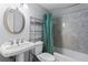Bathroom with oval mirror, pedestal sink, toilet and tub with shower and shower curtain at 300 Peachtree Ne St # 20 O, Atlanta, GA 30308