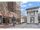 Exterior view of brick building next to white stone monument on brick-paved ground at 300 Peachtree Ne St # 20 O, Atlanta, GA 30308
