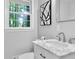 Bathroom with marble vanity, contemporary lighting, and a window with leafy outdoor view at 4669 Dunover Cir, Atlanta, GA 30360