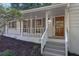 Inviting front entrance with a stained wood door, white painted brick, columns and gray painted steps at 4669 Dunover Cir, Atlanta, GA 30360