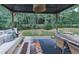 Relaxing backyard patio with a covered pavilion, an outdoor dining set, and views of the wooded backyard at 499 Bishop Ln, Woodstock, GA 30188