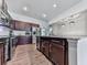 An open kitchen features wood flooring, stainless steel appliances, dark wood cabinets, and recessed lighting at 499 Bishop Ln, Woodstock, GA 30188