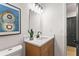 Bathroom featuring a wood vanity, quartz countertop, modern fixtures, and decorative artwork at 3208 Spruce Way, Atlanta, GA 30349