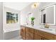 Bathroom featuring dual sinks, wood cabinets, quartz countertops, LED mirrors, and a large window at 3208 Spruce Way, Atlanta, GA 30349