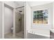Bathroom featuring a large bathtub, glass-door shower, and a new window at 3208 Spruce Way, Atlanta, GA 30349