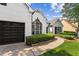 Beautiful home with manicured green landscaping and black garage door with a paver walkway and a large window at 3208 Spruce Way, Atlanta, GA 30349