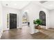 Bright foyer with hardwood floors, arched doorways and white walls leading to dining and living area at 3208 Spruce Way, Atlanta, GA 30349