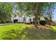 Charming home featuring a manicured lawn, mature trees, and attractive landscaping at 3208 Spruce Way, Atlanta, GA 30349